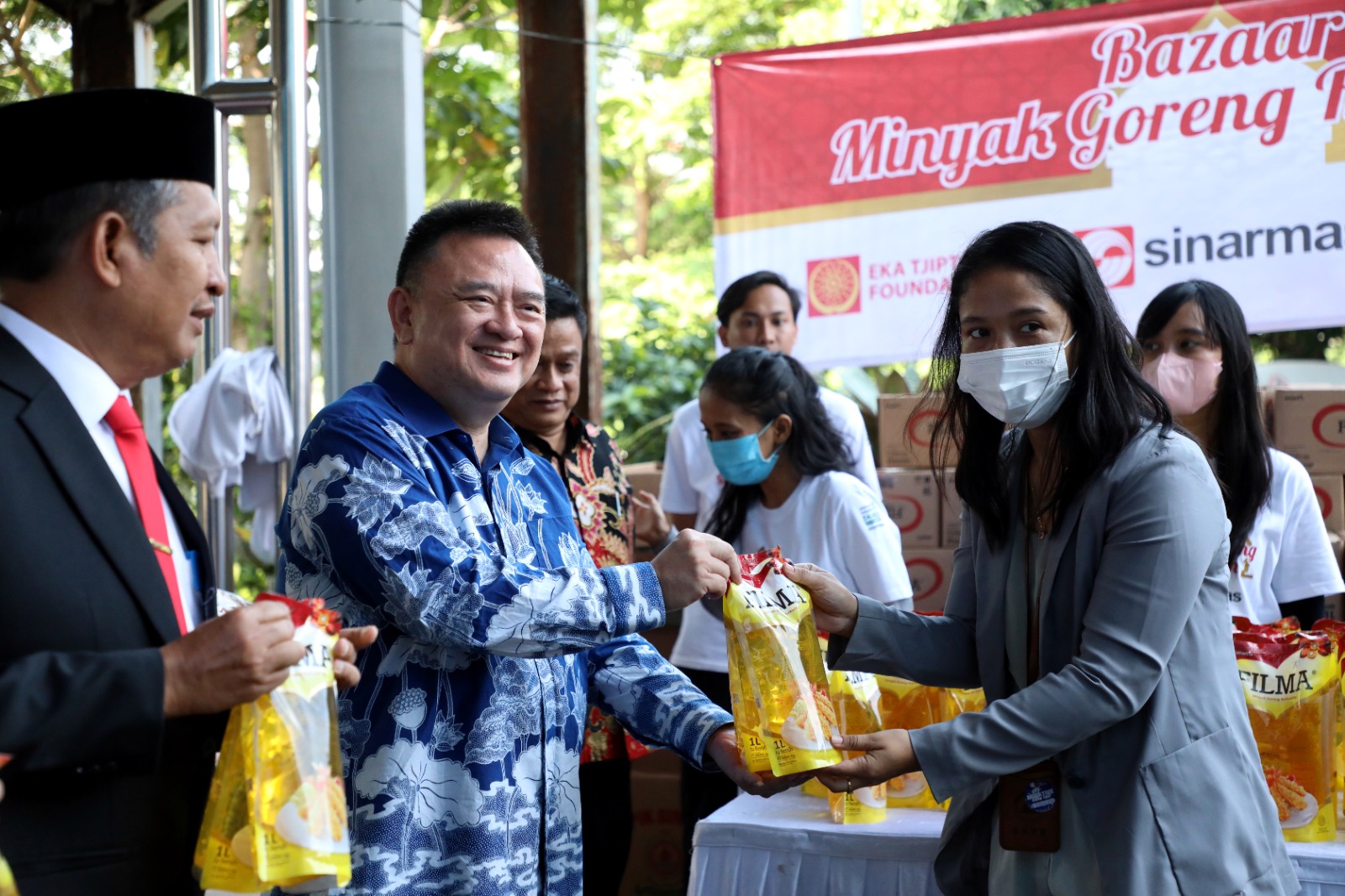 Direktur Eksekutif Sinar Mas Hong Tjhin (Tengah) menyerahkan minyak kepada salahsatu pembeli dalam acara bazar Ramadan yang digelar di Graha BNPB, Jakarta, Selasa (21/3). 